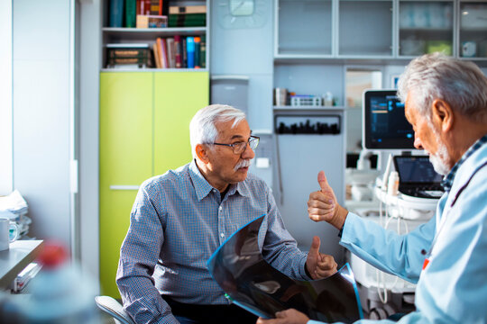 Senior patient and doctor reviewing x-ray results in clinic