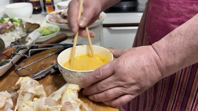 Preparing crab and lobster roe mixed with eggs in a home kitchen, with fresh ingredients arranged on a cutting board for cooking in China