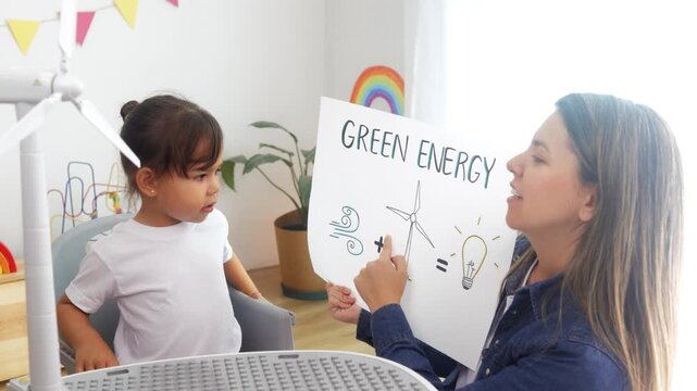 Latin child girl learning green energy with teacher at preschool classroom - Education sustainability concept