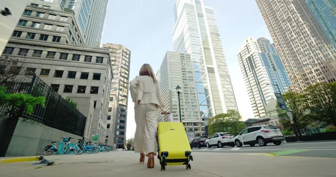 Woman Pulling Suitcase in Urban Area