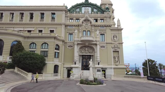 Grand casino building facade with people walking on famous monte carlo street.