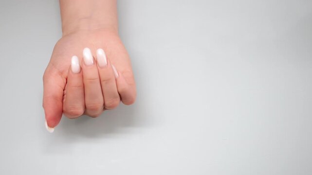 Close up of female hand opening palm revealing pill on clean background representing medication intake decision treatment and healthcare concept.