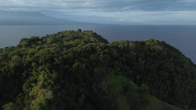 Drone aerial footage over lush tropical mountains on Apo Island Philippines with ocean backdrop and rich green landscape. Perfect cinematic clip for travel films nature content and storytelling.