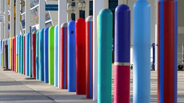 Colorful traffic bollards lining a modern city sidewalk