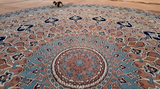 A close-up view of a detailed rug showing patterns and colors in a mosque.