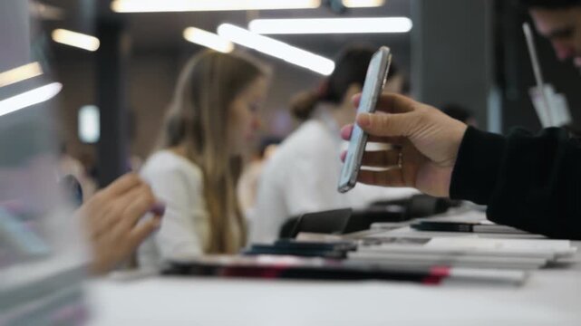 Close up of attendee scanning QR code on smartphone during conference registration process at modern business event reception desk.