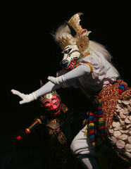 Obraz premium Traditional Indonesian Mask Dance Performance with Dramatic Lighting and Cultural Costume