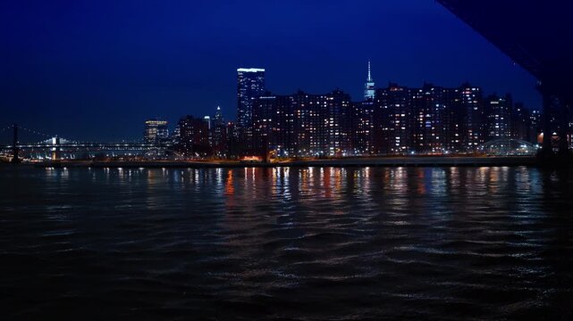 Manhattan Lower East Side residential skyline at night NYC. Detailed view of illuminated apartment buildings in Manhattan at night with Empire State Building visible.