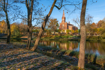 Fototapeta premium Lutheran Church of the Resurrection of Christ in Tsarskoye Selo on the bank of the 4th Lower Pond on a sunny autumn day, Pushkin, St. Petersburg, Russia