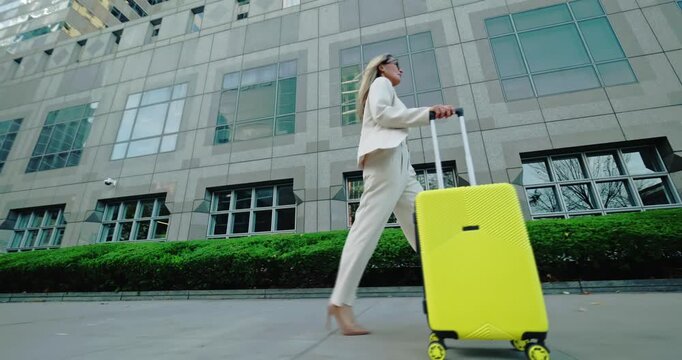 Woman walking with suitcase outdoors