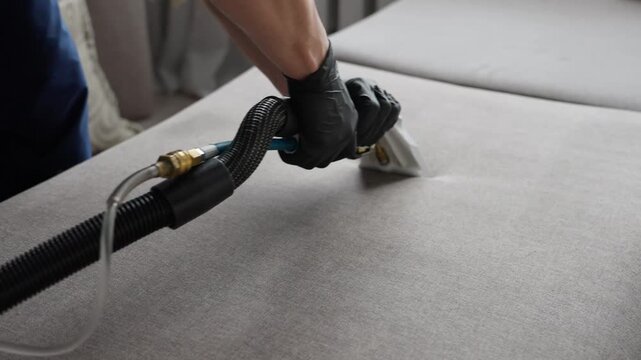 Expert Cleaning Of Tufted Sofa Fabric. Careful Cleaning Of Sofa Surface Using Extractor Tool. Specialized Cleaning Procedure With Extractor For Detailed Fabric And Button Area Restoration