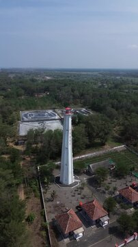 aerial video of lighthouse on the south coast of Java with a blue sea background with big rippling waves