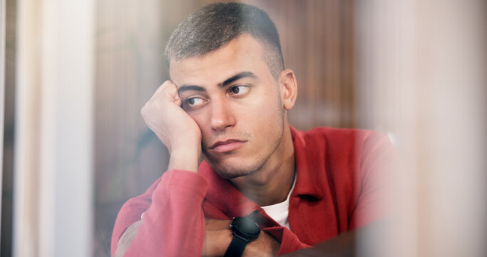 Window, thinking and man with depression, mental health and remember memory for grief in apartment. Sad, reflection and person with anxiety, contemplation or thoughts for mourning in home on weekend.