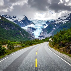 Fototapeta premium Asphalt road curves through lush green valley towards towering glacier and cloudy mountain peaks