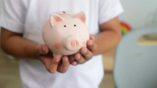 Child saving money in piggy bank. Financial future, money habits concept