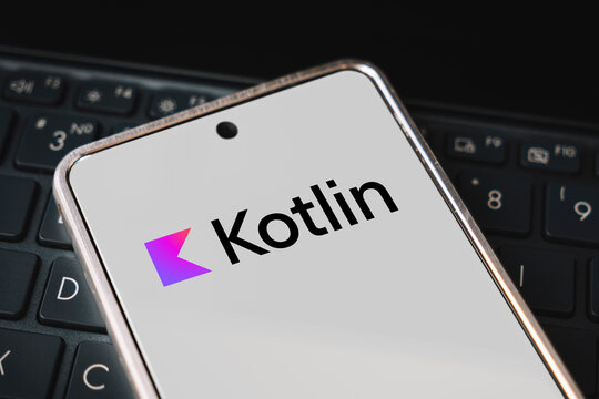 kotlin Programming language for mobile development, concept. Smartphone on the laptop keyboard, the programmer workplace. inscription kotlin on mobile phone screen ,