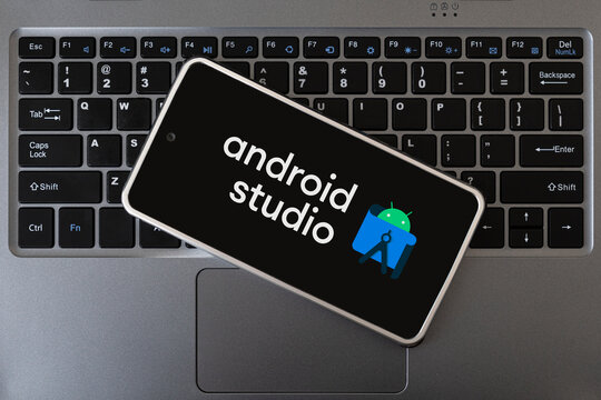 Programming mobile development, concept. Smartphone on the laptop keyboard. logo android studio on the mobile phone screen