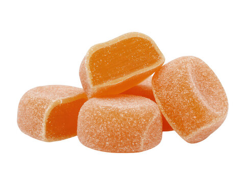 Orange chewy candies in rectangular shapes on black candy sweets isolated on a transparent background