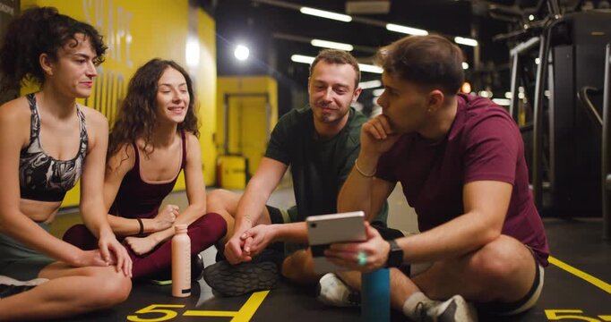 Friends gather at a fitness center for group exercise planning and strategy discussion with focus on workouts and routines
