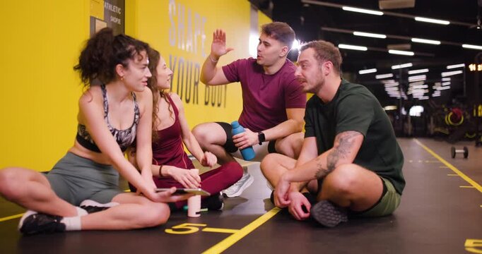Friends gather at fitness center to share tips and ideas for exercise during group workout session in the afternoon