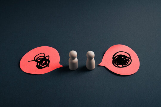 Emotional conflict in communication concept with wooden figures and chaotic speech bubbles