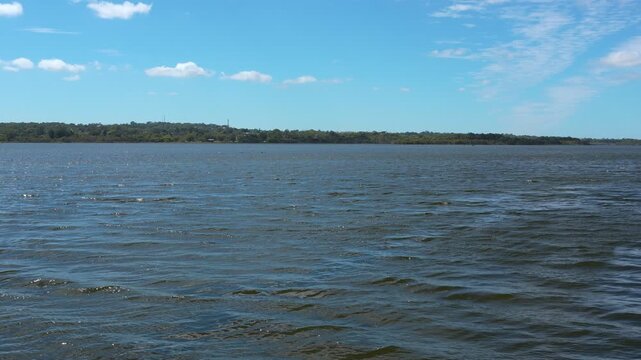 Lake Joondalup from Neil Hawkins Park's viewing platform on a sunny day, showcasing tranquil waters and clear skies in this panoramic shot.