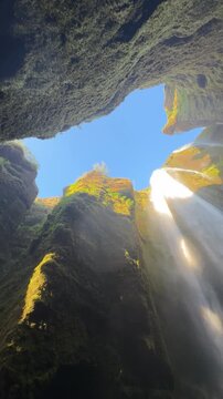 Inside the narrow canyon of Gljufrabui waterfall with water cascading from above, South Iceland