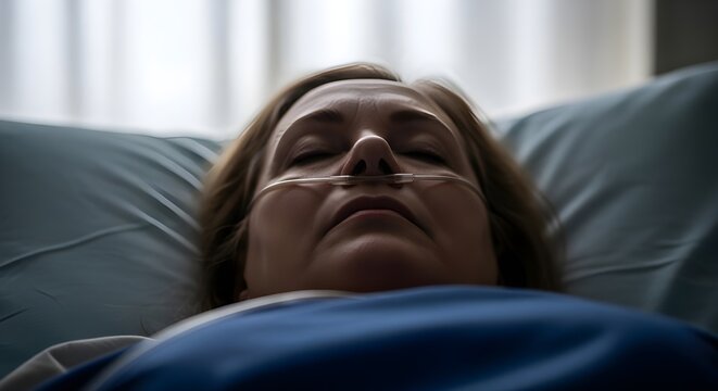 Elderly woman patient with nasal cannula oxygen tube in hospital bed, senior female lying unconscious in clinic, medical healthcare and palliative care