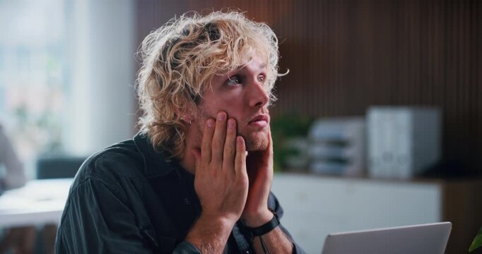 Bored, stress and man in office with laptop for creative project with deadline at startup business. Fatigue, computer and male magazine editor with burn out for article with publishing in workplace.