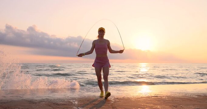 Fit woman jumping rope at the beach during summer vacation