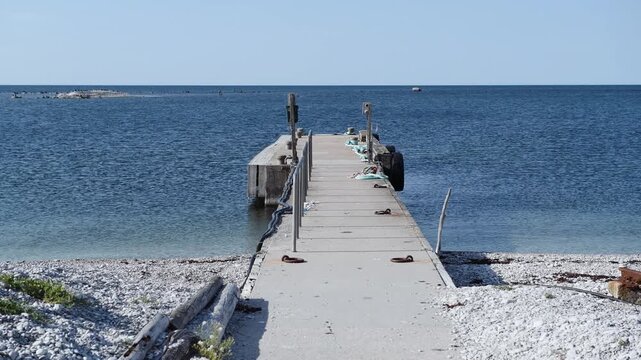 Boat pier on Stora Karls&ouml; island extending into the Baltic Sea with rocky shoreline, Gotland, Sweden