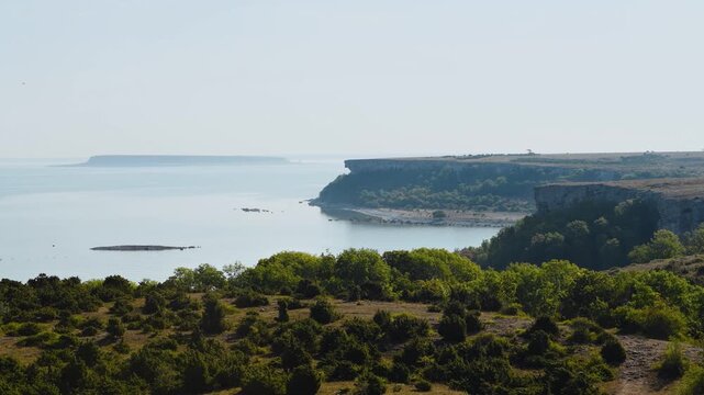 Elevated view from Stora Karls&ouml; cliffs with Lilla Karls&ouml; island on the horizon in soft morning haze, Gotland, Sweden
