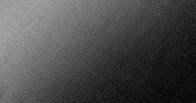 Seamless Abstract black texture. A slow, smooth loop rotation of a dark, rough surface, gently rotating under the light, creating subtle highlights.