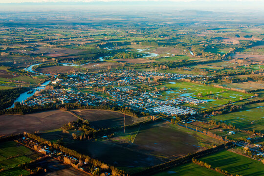 A wide aerial shot of Angol, Chile, showcasing the city surrounded by rivers, farmland, and green landscapes in the Araucan&iacute;a Region