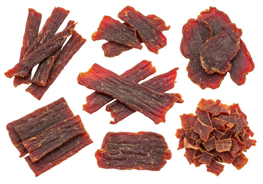 Assortment of delicious beef jerky pieces with varied shapes and textures isolated on white background