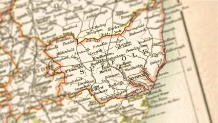 Fototapeta premium Macro close up of a vintage map highlighting Suffolk in the United Kingdom, showcasing detailed cartography, major towns, and classic antique textures ideal for travel, geography, and historical theme