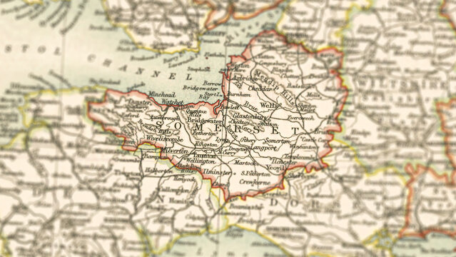 Macro close up of a vintage map highlighting Somerset in the United Kingdom, showcasing detailed cartography, major towns, and classic antique textures ideal for travel, geography, and historical them