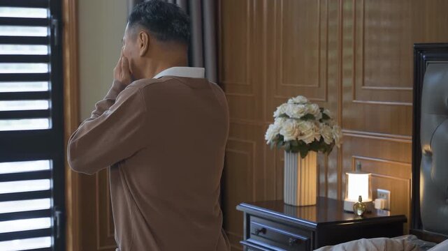Sad depressed senior man crying covering face with hands, regret for past mistake, loss or grief on bed room. Mature male emotional with old memory, nostalgia or mourning lost love for loneliness