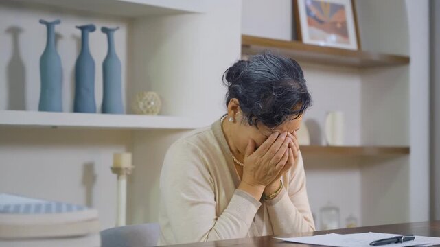Sad depressed senior man crying covering face with hands, regret for past mistake, loss on bed room. Female in tears worried about health problems, nostalgia or mourning lost love for loneliness