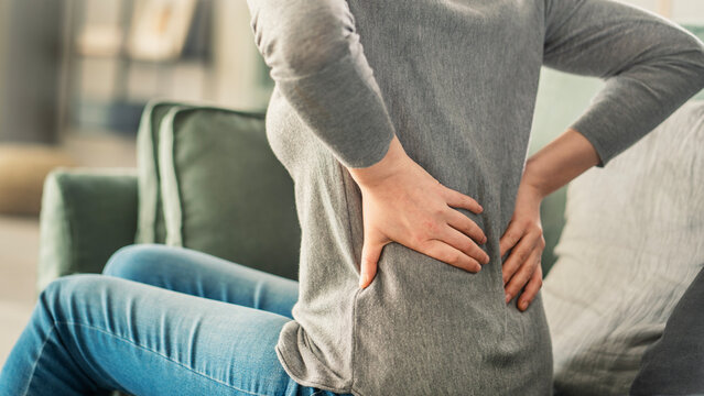 Woman with back pain in home