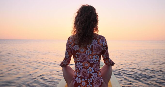 Young woman walking on sup board by the sea during summer vacation. Slow motion