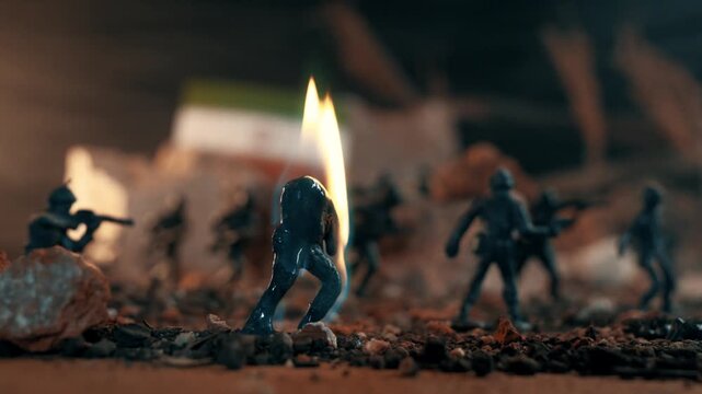 Macro shot of a plastic toy soldier engulfed in flames and melting down to the ground. Symbolic representation of war, conflict and terror