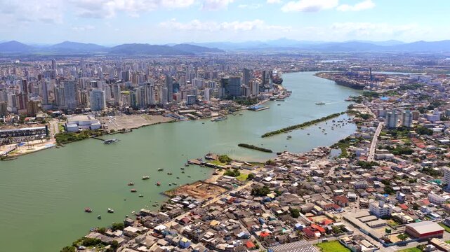 Itajai city and port along the Itajai Acu River in Santa Catarina, South Brazil, with dense urban skyline, vessels and waterfront infrastructure, major logistics hub on the Atlantic coast drone reveal