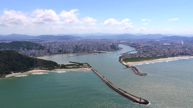 Itajai and Navegantes harbor at the Itajai Acu River mouth with breakwaters, coastal skyline and Atlantic shoreline in Santa Catarina, Brazil, urban port landscape, aerial view, high angle, wide shot.