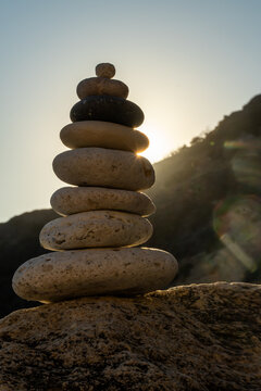 Cairn balance stones stacked on a large rock during a peaceful sunset, representing stability and spirituality outdoors