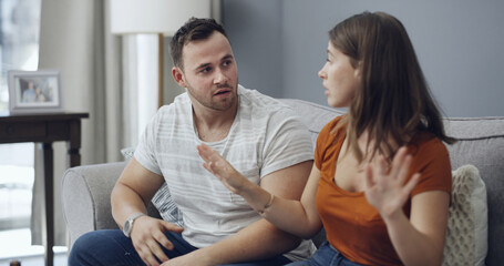 Obraz premium Fighting, upset and couple on sofa in home with relationship problem, cheating or affair conflict. Argument, conversation and man with woman for marriage disagreement in living room at apartment.