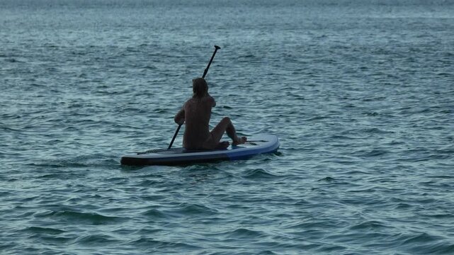 Paddleboarding Woman Silhouette Rowing On Dark Choppy Ocean Vertical video
