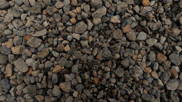 Top view of crushed dark grey gravel stone texture background. Flat lay.