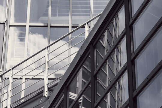 Abstract modern steel lines across a glass window on an architectural building facade with strong reflection and clean geometric rhythm