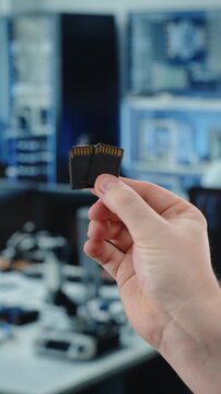 Hands holding microSD cards in office workspace